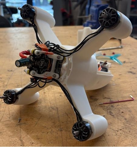 Underside of the unpainted airframe with four motors wired to the stack